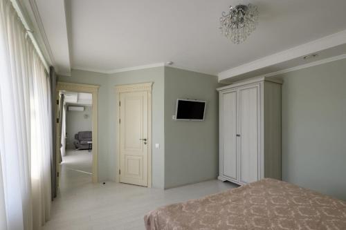 a bedroom with a bed and a tv on the wall at Sagora Hotel in Chernivtsi