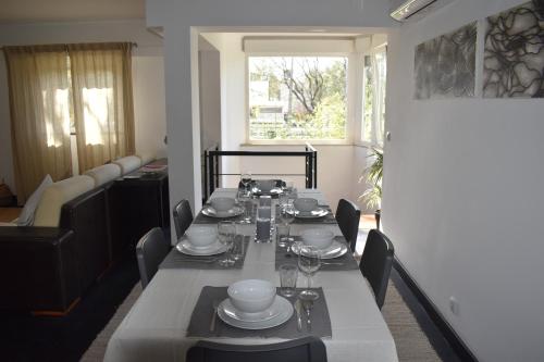a dining room with a table with plates and glasses at BFF - Beach Family and Friends in Carcavelos