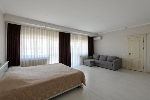 a bedroom with a bed and a couch at Sagora Hotel in Chernivtsi