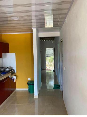 a kitchen with yellow walls and a hallway at Casa Murillo in San Antero