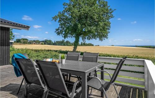 a table and chairs on a deck with a tree at Holiday Home Brombærvænget Hejls I in Hejls