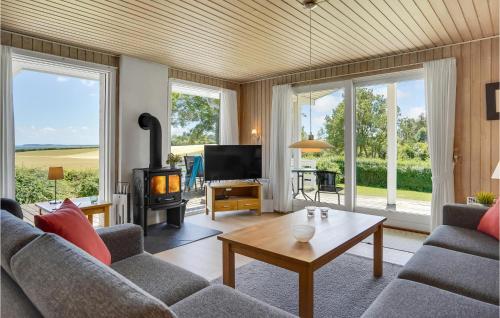 a living room with a couch and a tv at Holiday Home Brombærvænget Hejls I in Hejls