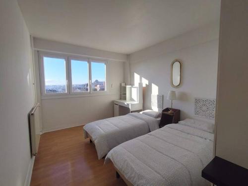 two beds in a room with two windows at 5 mins to metro La defense, 2 bedrooms and 1 salon in Puteaux