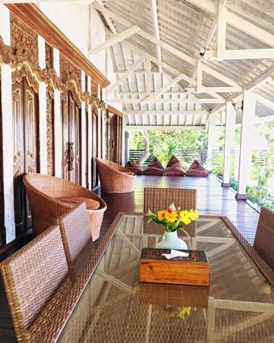a lobby with chairs and a table with a vase of flowers at Imaj Private Villas in Senggigi 