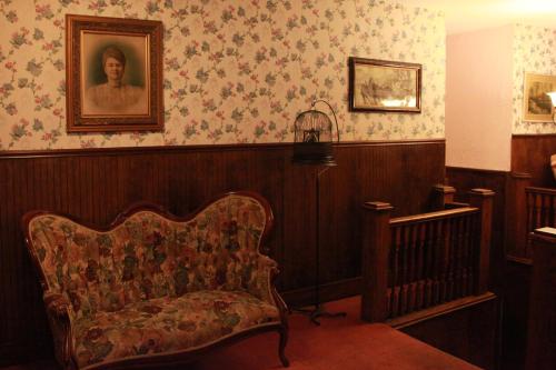 a room with a chair and a portrait on the wall at The Winter Inn in Greenville
