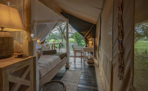 a bedroom with a tent with chairs and a table at Mara Major Camp in Masai Mara