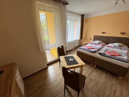 カルロヴィ・ヴァリにあるPenzion Pavelのベッドルーム1室(ベッド1台、テーブル、窓付)