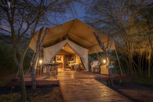 a tent with a table and chairs inside of it at Mara Major Camp in Masai Mara