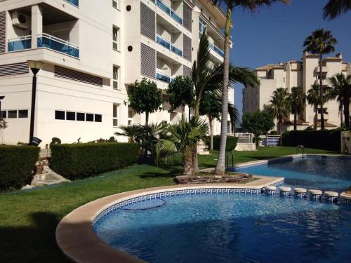a swimming pool in front of a large building at Albir Apartment Lina in Albir