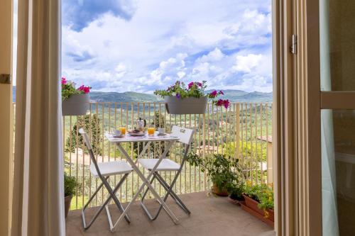 a table and chairs on a balcony with a view at Gladys, appartamento con vista a Fiesole in Fiesole