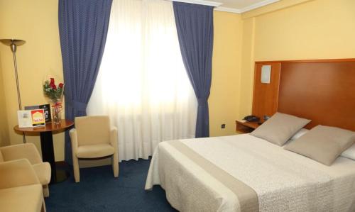 Habitación de hotel con cama, mesa y ventana en Motel Punta Cana en Santiago de Compostela