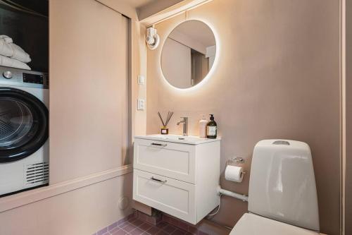 uma casa de banho com um lavatório e uma máquina de lavar roupa em Dinbnb Homes I #1 BNB in Bergen I Jacuzzi & Parking & Location em Bergen