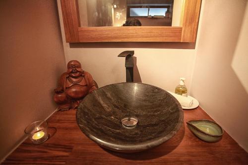 a bathroom with a stone sink on a wooden table at Penzion Dobré Časy in Poděbrady