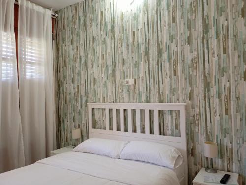 a bedroom with a white bed with a wallpaper at La Cabana in Organyà