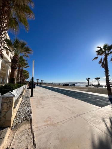 un trottoir avec des palmiers à côté de la plage dans l'établissement Sunset Sea View - Premium Apartment 2BR, à Durrës
