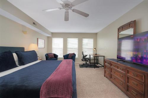 1 dormitorio con 1 cama grande y TV de pantalla plana en Lux Townhouse, Walk to All, Sleeps 6 Adults, en Louisville