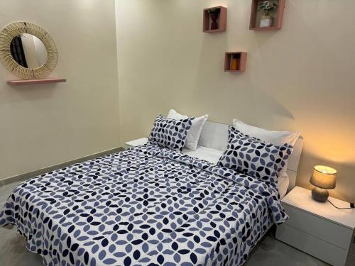 een slaapkamer met een blauw en wit bed met kussens bij Sall Residence Mbour, Appartement 3 in Mbour