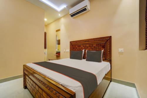 a bedroom with a large bed in a room at OYO Flagship Classique Inn Farm Stay in Coimbatore