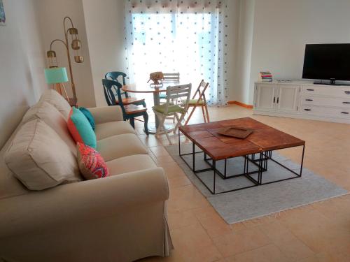 uma sala de estar com um sofá e uma mesa em Casa dos Medros em São Martinho do Porto