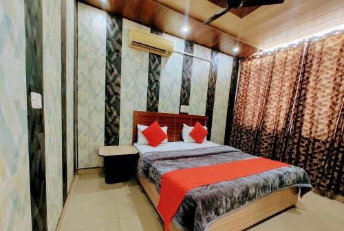 Hotel Grand في Zirakpur: غرفة نوم بسرير ومخدات حمراء