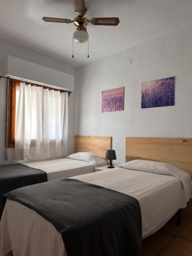 1 dormitorio con 2 camas y ventilador de techo en Apartamento en la playa, en La Mata