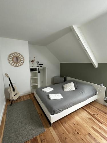 a bedroom with a bed and a guitar in it at Le Ker Maclow in Saint Malo