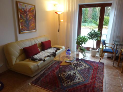 uma sala de estar com um sofá e uma mesa de vidro em Solrosen i Simrishamn - Österlen em Simrishamn