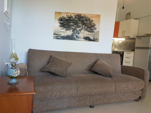 a couch in a living room with a tree on the wall at Elia Guesthouse in Kissamos