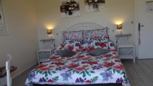 1 Schlafzimmer mit einem Bett mit Blumenbettdecke in der Unterkunft Chambres d'Hôtes Le Belvédère in Bagnères-de-Bigorre