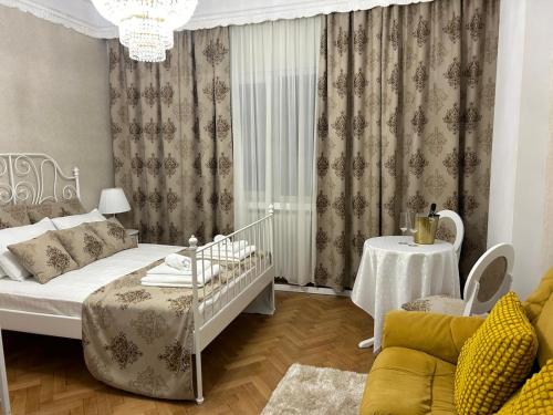 a living room with a bed and a table at UNIVERSITATE-ELEGANT-MIC DEJUN inclus in Bucharest