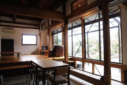 a dining room with a table and chairs and windows at 小宿　福右衛門邸 in Kagoshima