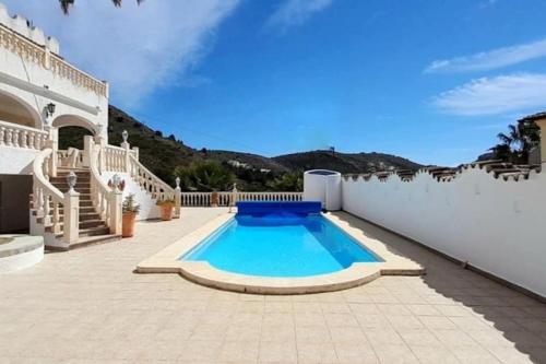 a swimming pool on a patio of a house at Vista Portet, sleeps 10, Private Pool, Sea Views, Squash, 1 km from El Portet beach in Teulada