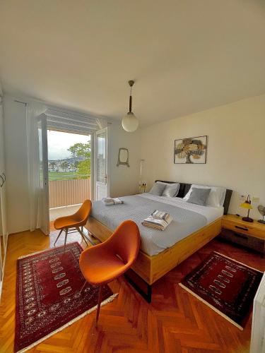 a bedroom with a bed with two chairs and a window at Dinka Old Town Apartment in Trogir