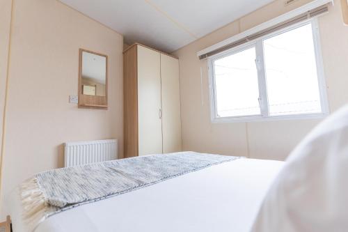 a bedroom with a bed and a window at Marine Holiday Park in Rhyl