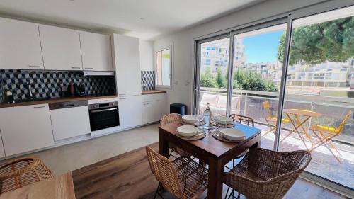 une cuisine avec une table et des chaises et une cuisine avec une fenêtre dans l'établissement Les Appartements De Lina - Appartement Patz - Self Check-In -, à La Grande Motte