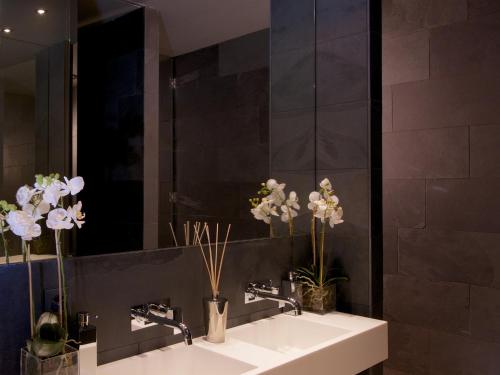 a bathroom with two sinks and a mirror at VISIONAPARTMENTS Wolframplatz - contactless check-in in Zürich