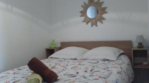1 dormitorio con 1 cama con espejo en la pared en BELLE appartement T2 neuf et en plein centre, en Ax-les-Thermes