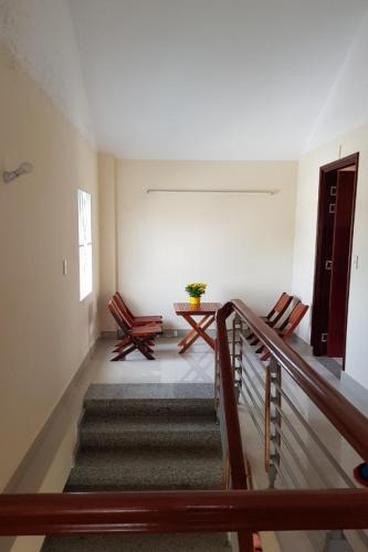a room with two chairs and a table and stairs at Mifa Homestay in Hương Trà