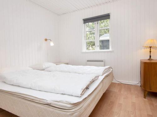 Holiday home Ørsted V في Ørsted: غرفة نوم بيضاء مع سرير كبير ونافذة