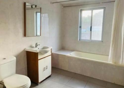 a bathroom with a tub and a sink and a toilet at Residencial Sao Miguel in Calheta de São Miguel