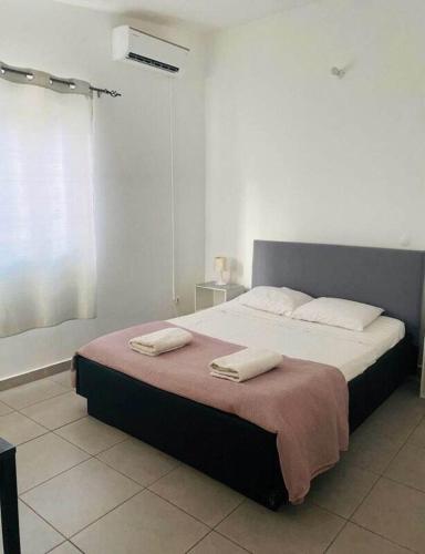 1 dormitorio con 1 cama grande y 2 toallas. en Residencial Sao Miguel, en Calheta