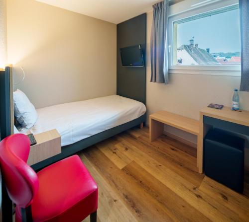a small room with a bed and a red chair at Logis Hôtel Restaurant Ritter'Hoft in Morsbronn-les-Bains