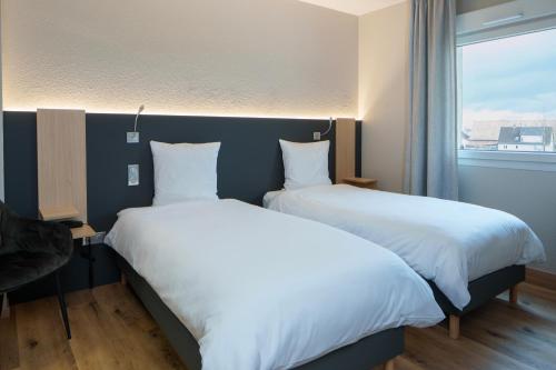 two beds sitting next to each other in a room at Logis Hôtel Restaurant Ritter'Hoft in Morsbronn-les-Bains