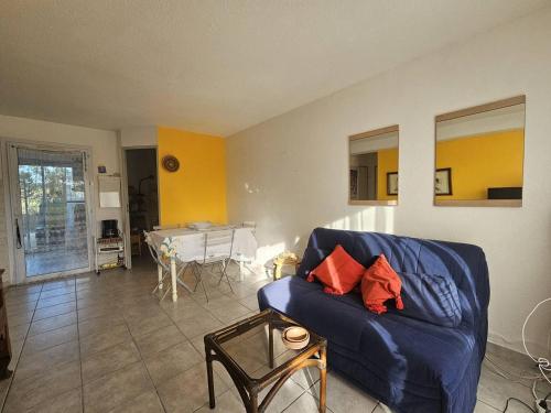 un salon avec un canapé bleu et une table dans l'établissement OREE DU GOLF I Joli T3 proche golf piscine Cap d Agde, au Cap d'Agde