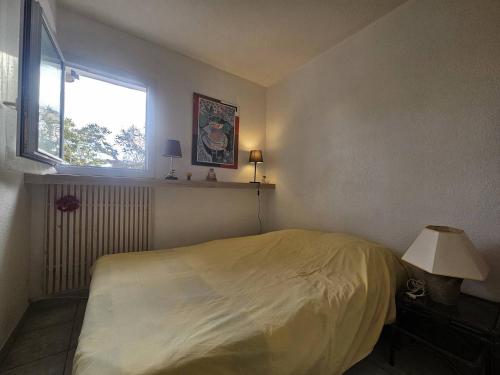 une chambre avec un lit et une fenêtre dans l'établissement OREE DU GOLF I Joli T3 proche golf piscine Cap d Agde, au Cap d'Agde