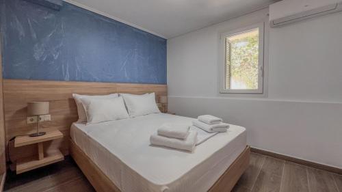 1 dormitorio con 1 cama con pared azul en Spyros Stone Apartment en Lazaráta
