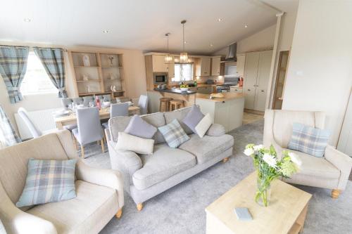 a living room with two couches and a kitchen at Marine Holiday Park in Rhyl