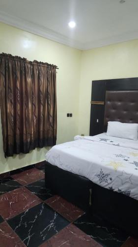 een slaapkamer met een groot bed en een raam bij Paviosca Hotel in Umuahia