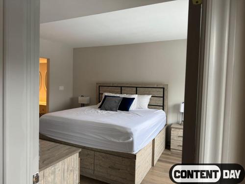 een slaapkamer met een bed met witte lakens en kussens bij Valley Vista Haven - Exquisite Condo Retreat with Jacuzzi - Top Floor Romance - Self-Check-in - Gourmet Kitchen - Heated Pool Paradise in Shanty Bay