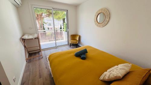 une chambre avec un lit jaune et une fenêtre dans l'établissement Les Appartements De Lina - Appartement Patz - Self Check-In -, à La Grande Motte